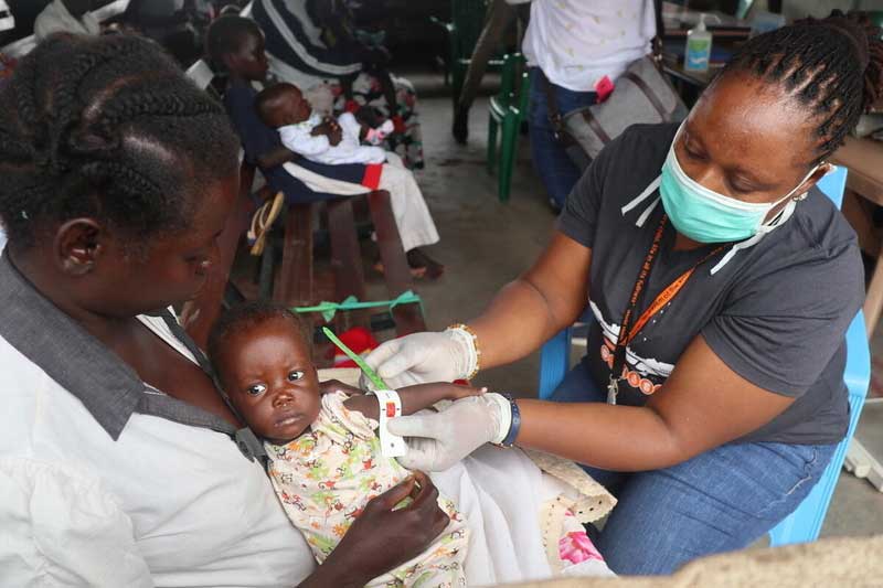 Au Soudan du Sud, une membre du personnel Vision Mondiale mesure le tour de bras d’un bébé.