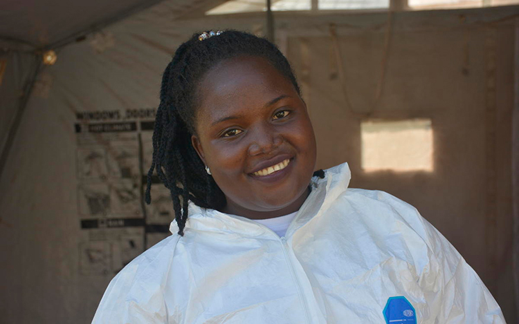 Vêtue d’une combinaison contre les matières dangereuses, une femme sourit dans un centre de santee du Soudan du Sud.